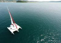 trimaran yacht charter crew in turquoise uniform on deck at sea